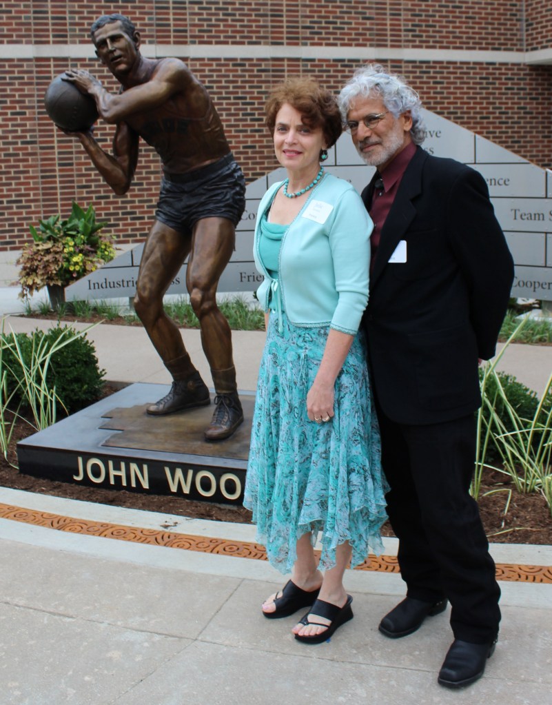 Photo of artists Julie Rotblatt-Amrany and Omri Amrany with their bronze sculpture of John Wooden for Purdue University